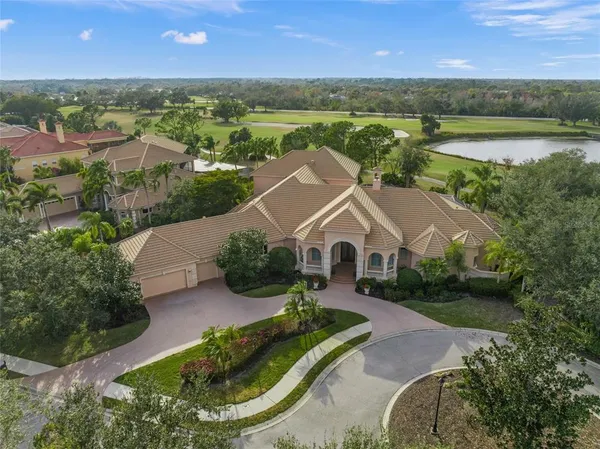 an aerial view of a house with a garden and lake view