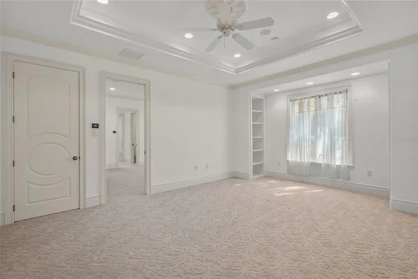 an empty room with a ceiling fan and a window