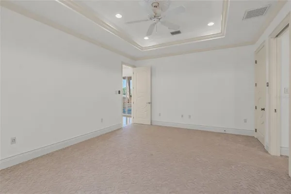 a big room with chandelier fan and wooden floor