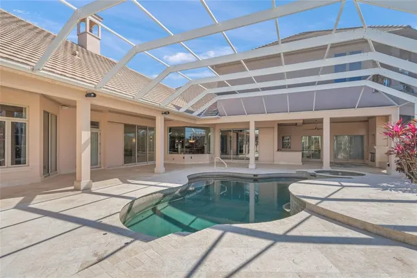 a spacious bedroom with a large bed and a chandelier