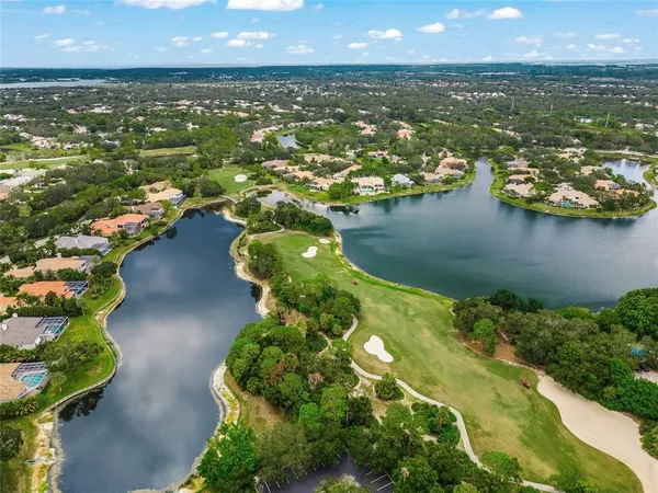 an aerial view of residential houses with outdoor space and lake view