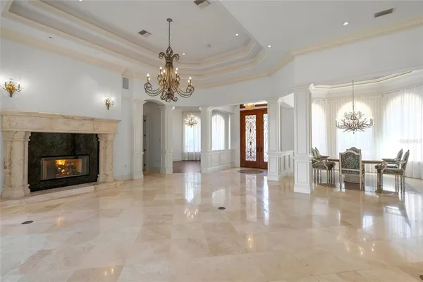a view of a livingroom with fireplace dining space and a chandelier