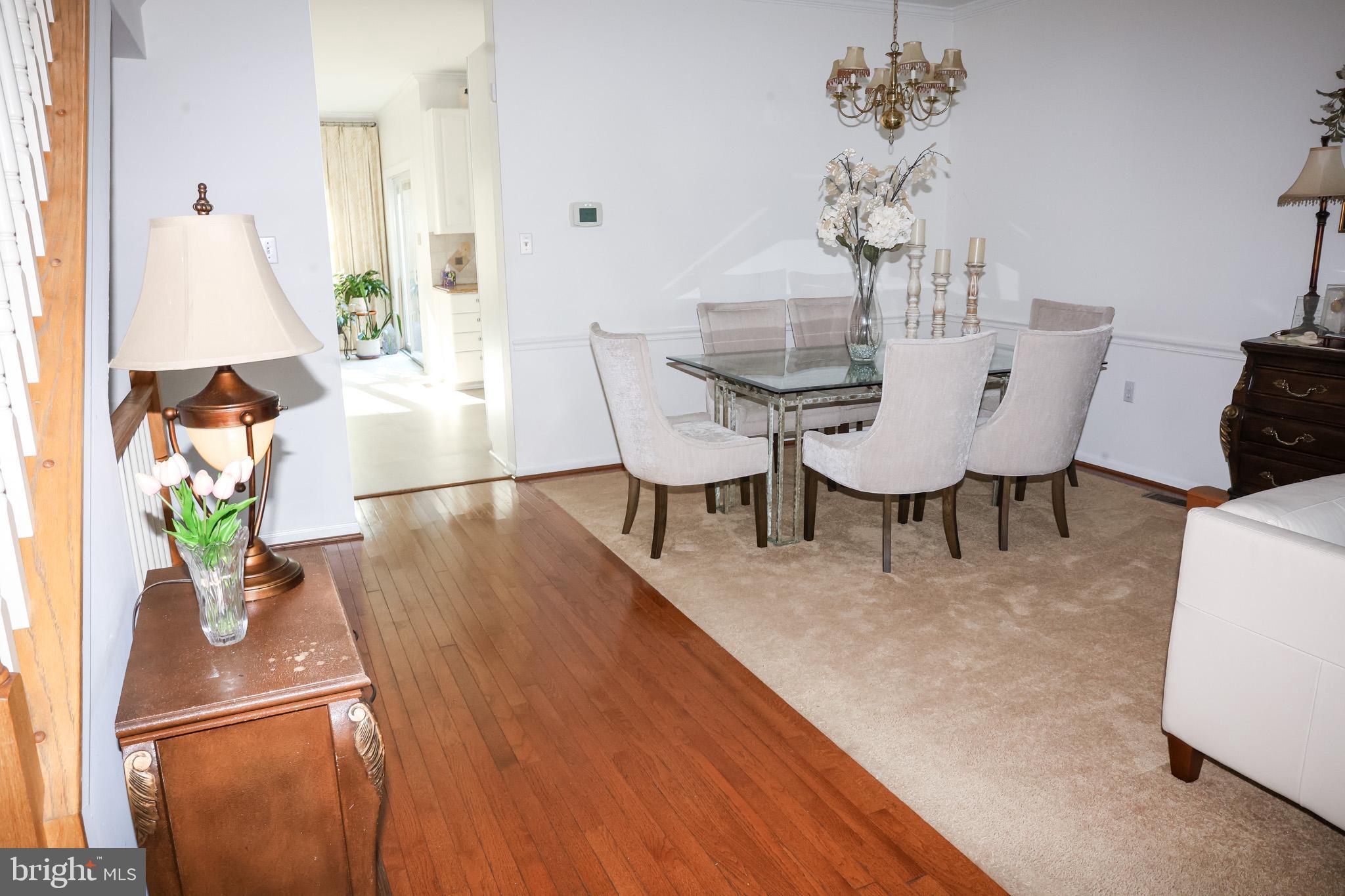 4234 Huntshire Road Randallstown, MD 21133 - Photo 13 of 43 a dining room with furniture potted plants and wooden floor
