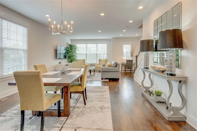 a view of a dining room with furniture a chandelier and wooden floor