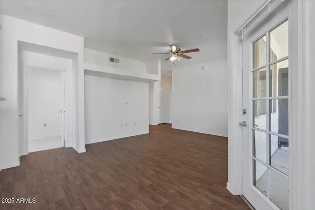 a view of a kitchen with fridge and wooden floor