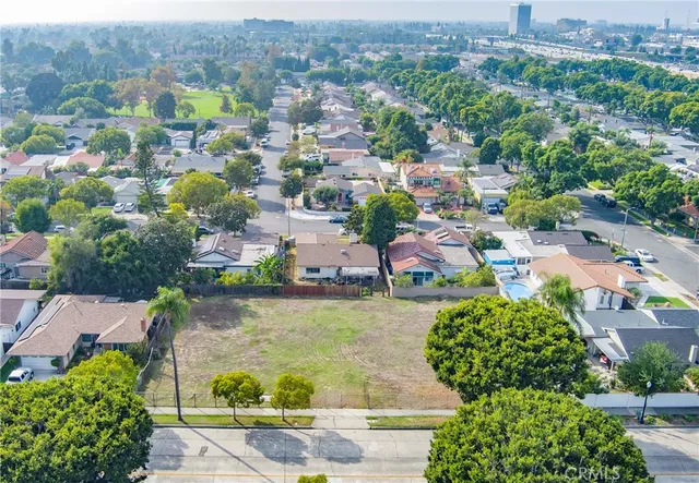 an aerial view of a city with lots of residential buildings ocean and mountain view in back