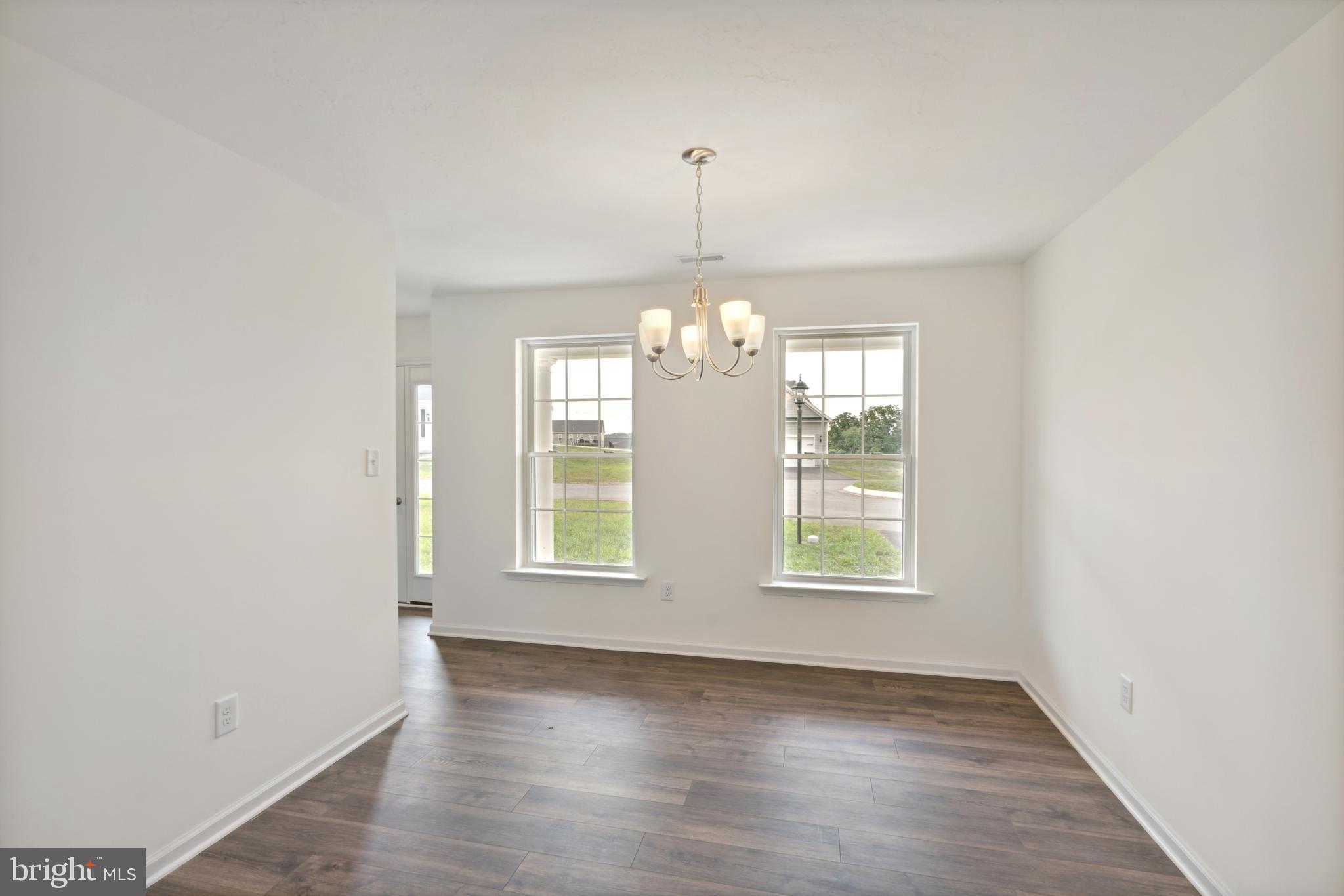 62 Flint Drive Hanover, PA 17331 - Photo 7 of 18 an empty room with wooden floor chandelier and windows