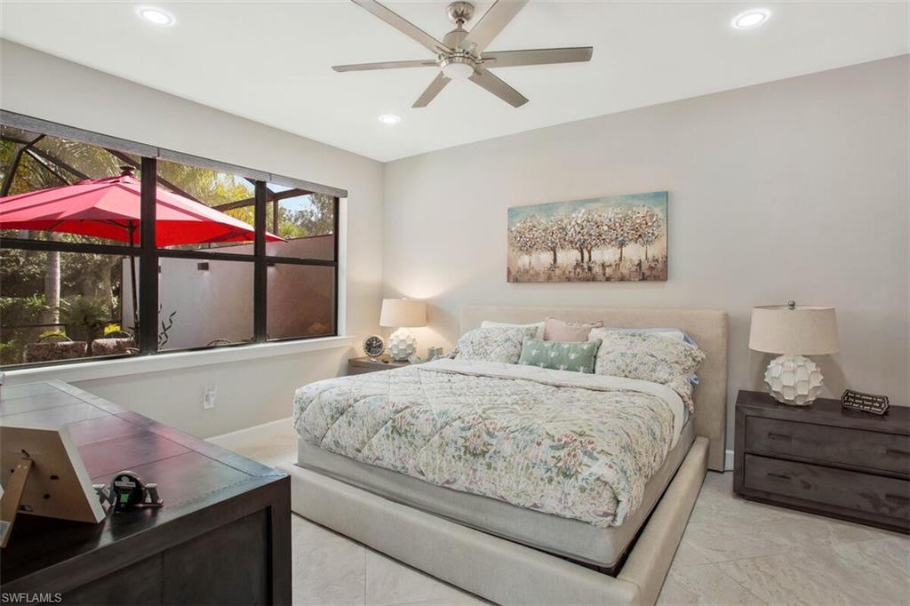 7682 Jacaranda Lane Naples, FL 34114 - Photo 20 of 44 a bedroom with a bed and chandelier