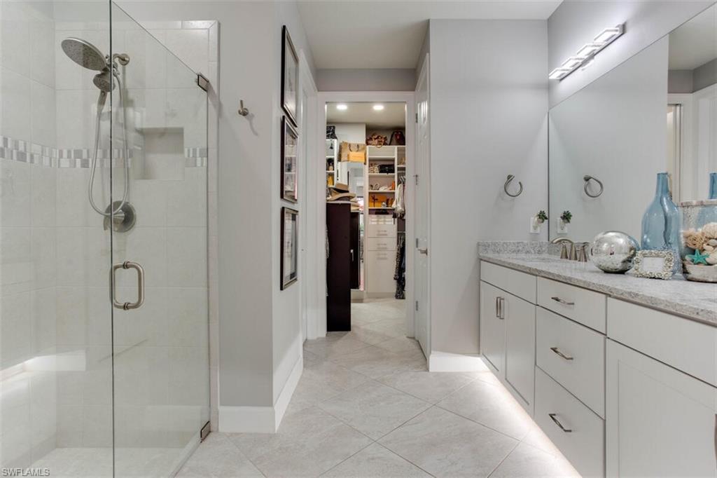 7682 Jacaranda Lane Naples, FL 34114 - Photo 21 of 44 a bathroom with a granite countertop sink a shower and a mirror