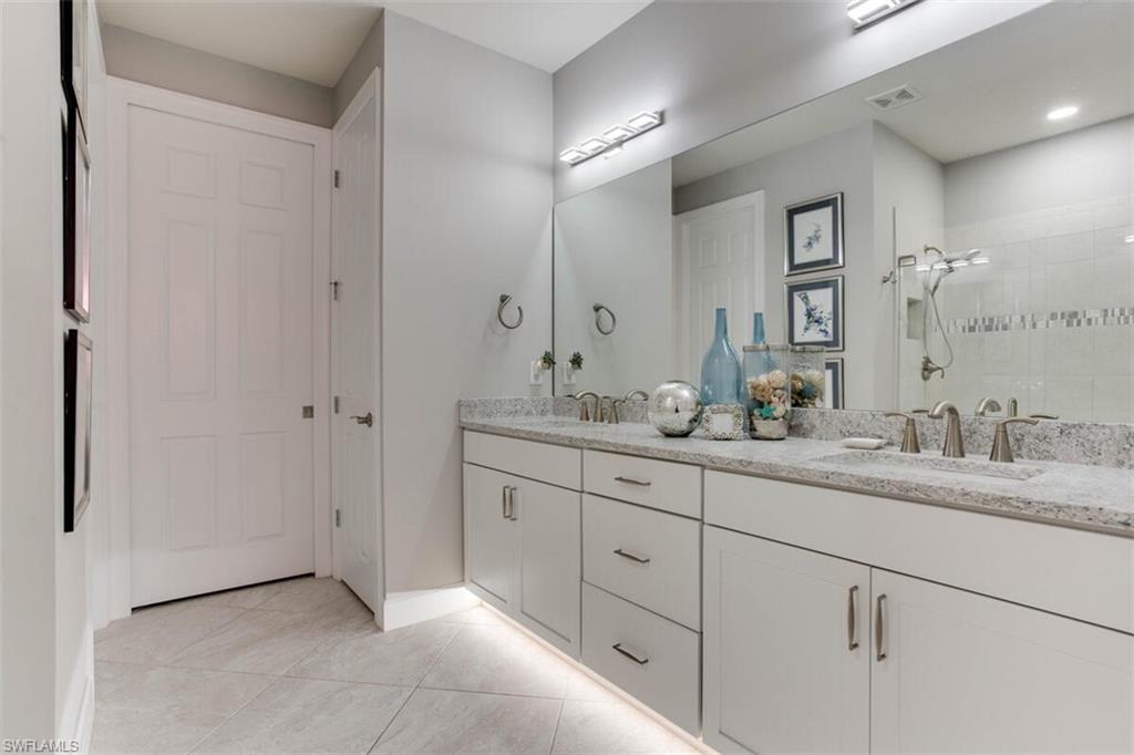 7682 Jacaranda Lane Naples, FL 34114 - Photo 24 of 44 a bathroom with double sink and a mirror