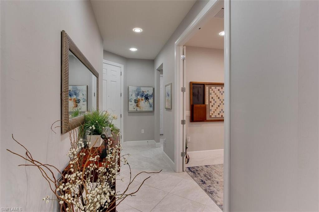 7682 Jacaranda Lane Naples, FL 34114 - Photo 3 of 44 a hallway with wooden floor and a potted plant