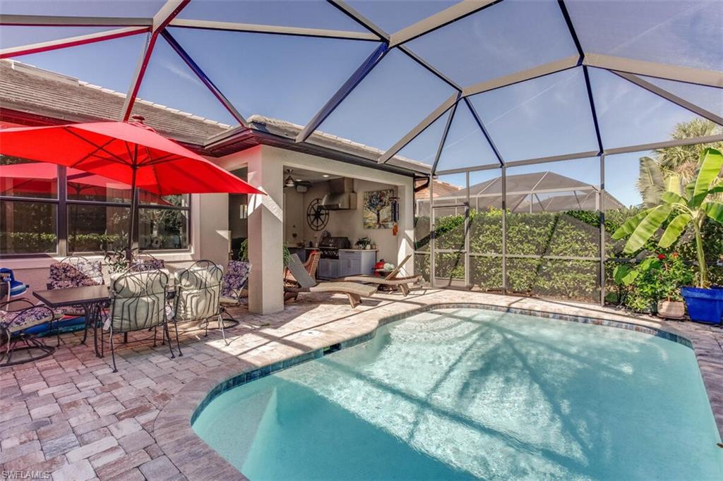 7682 Jacaranda Lane Naples, FL 34114 - Photo 31 of 44 a view of a patio with a table and chairs under an umbrella