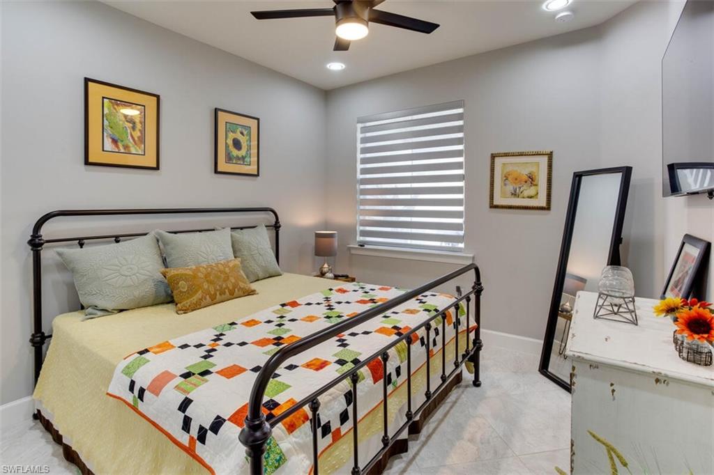 7682 Jacaranda Lane Naples, FL 34114 - Photo 5 of 44 a bedroom with a bed a painting on the wall and a window