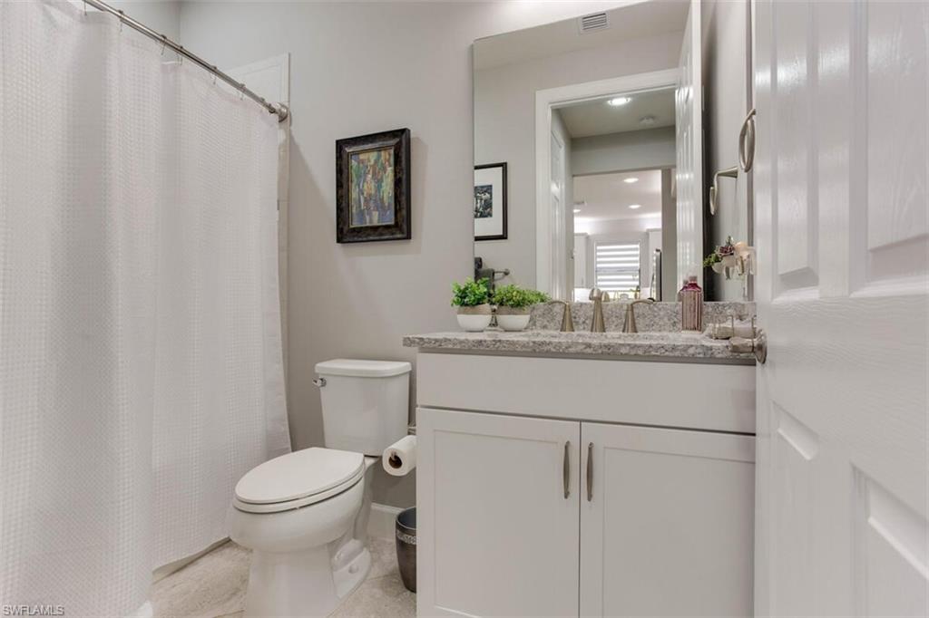 7682 Jacaranda Lane Naples, FL 34114 - Photo 6 of 44 a bathroom with a toilet sink and mirror