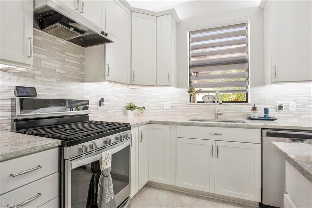 7682 Jacaranda Lane Naples, FL 34114 - Photo 8 of 44 a kitchen with white cabinets appliances and a window