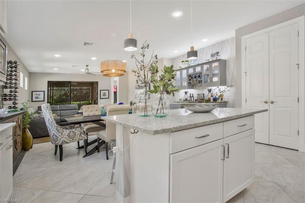 7682 Jacaranda Lane Naples, FL 34114 - Photo 9 of 44 a kitchen with cabinets and chairs