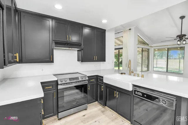 a kitchen with stainless steel appliances granite countertop a sink stove and cabinets