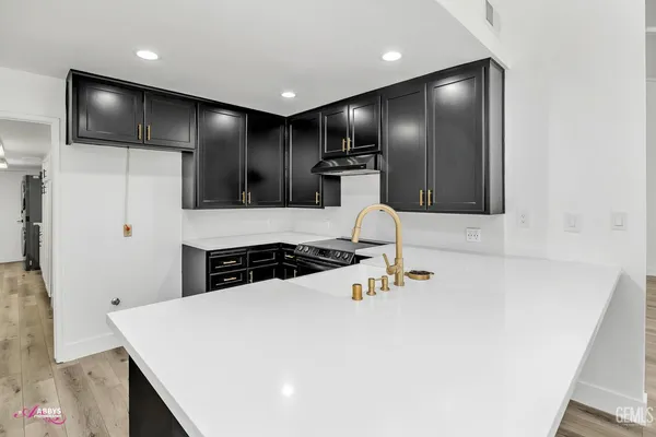a kitchen with stainless steel appliances granite countertop a sink stove and cabinets