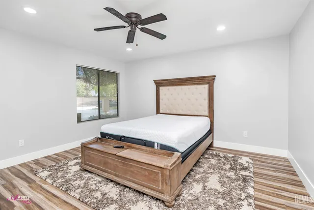 a bedroom with a large bed and a chandelier fan