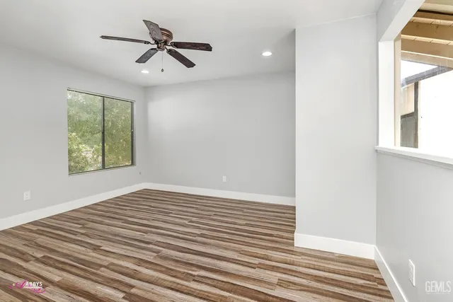 a view of room with window ceiling fan and wooden floor