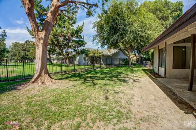a view of a house with backyard and a tree