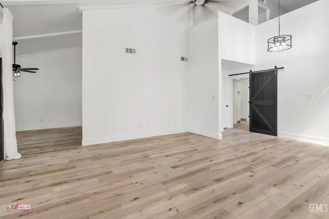 a view of an empty room with closet and a ceiling fan