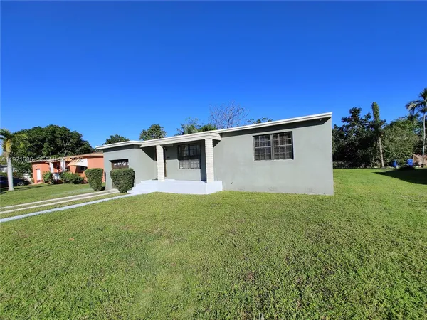 a front view of a house with a yard and trees