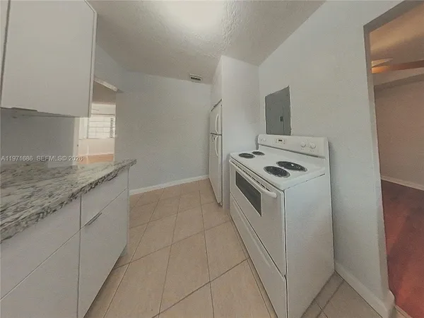 a kitchen with granite countertop a sink stove and cabinets