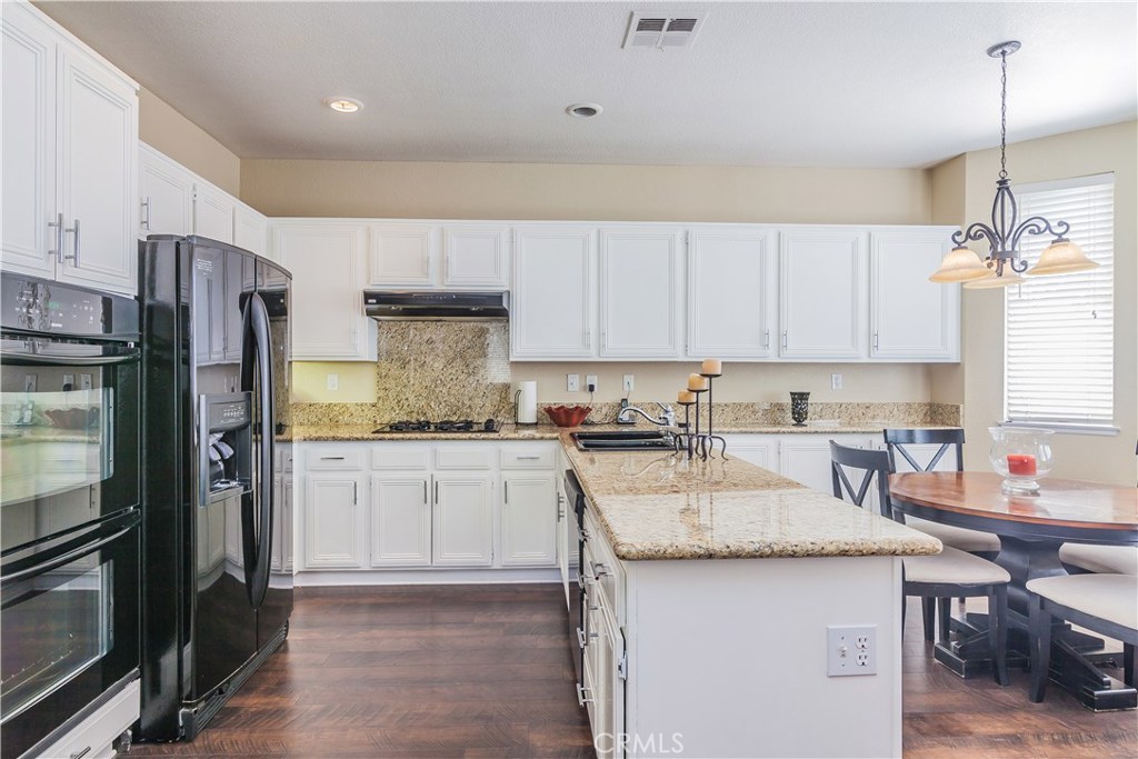 743 Orchard Loop Azusa, CA 91702 - Photo 14 of 39 a kitchen with stainless steel appliances granite countertop a sink stove refrigerator and cabinets