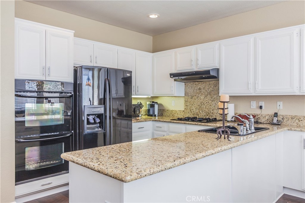 743 Orchard Loop Azusa, CA 91702 - Photo 15 of 39 a kitchen with refrigerator and stove