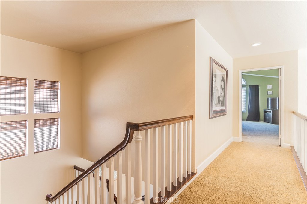 743 Orchard Loop Azusa, CA 91702 - Photo 23 of 39 a view of a hallway with wooden floor and staircase