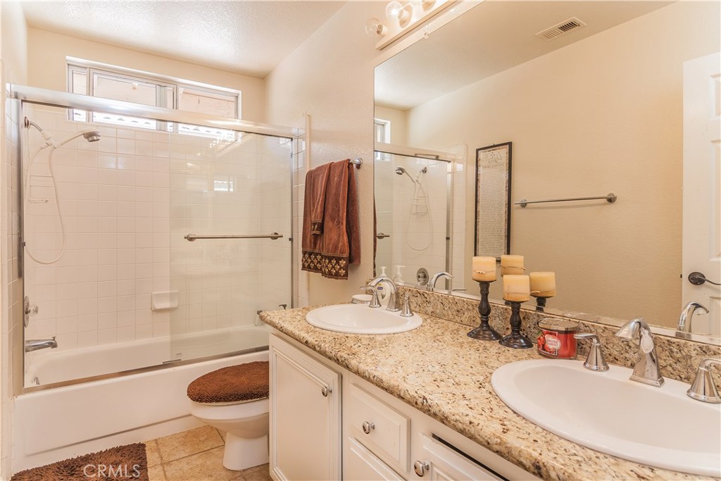 743 Orchard Loop Azusa, CA 91702 - Photo 31 of 39 a bathroom with a granite countertop sink toilet and shower