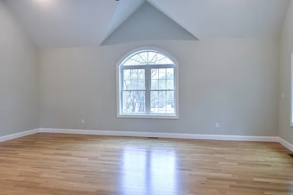 an empty room with wooden floor windows and a wooden floor