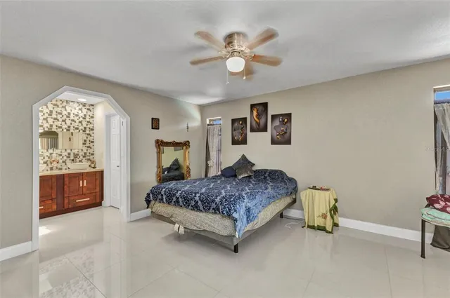 a spacious bedroom with a large bed and a chandelier