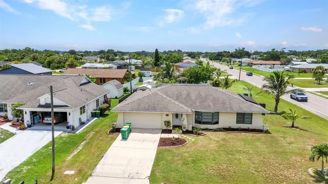 an aerial view of a house with swimming pool and a yard