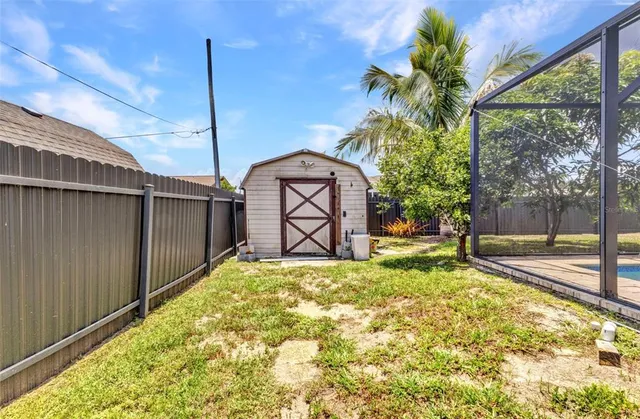 a view of swimming pool with a yard and palm trees