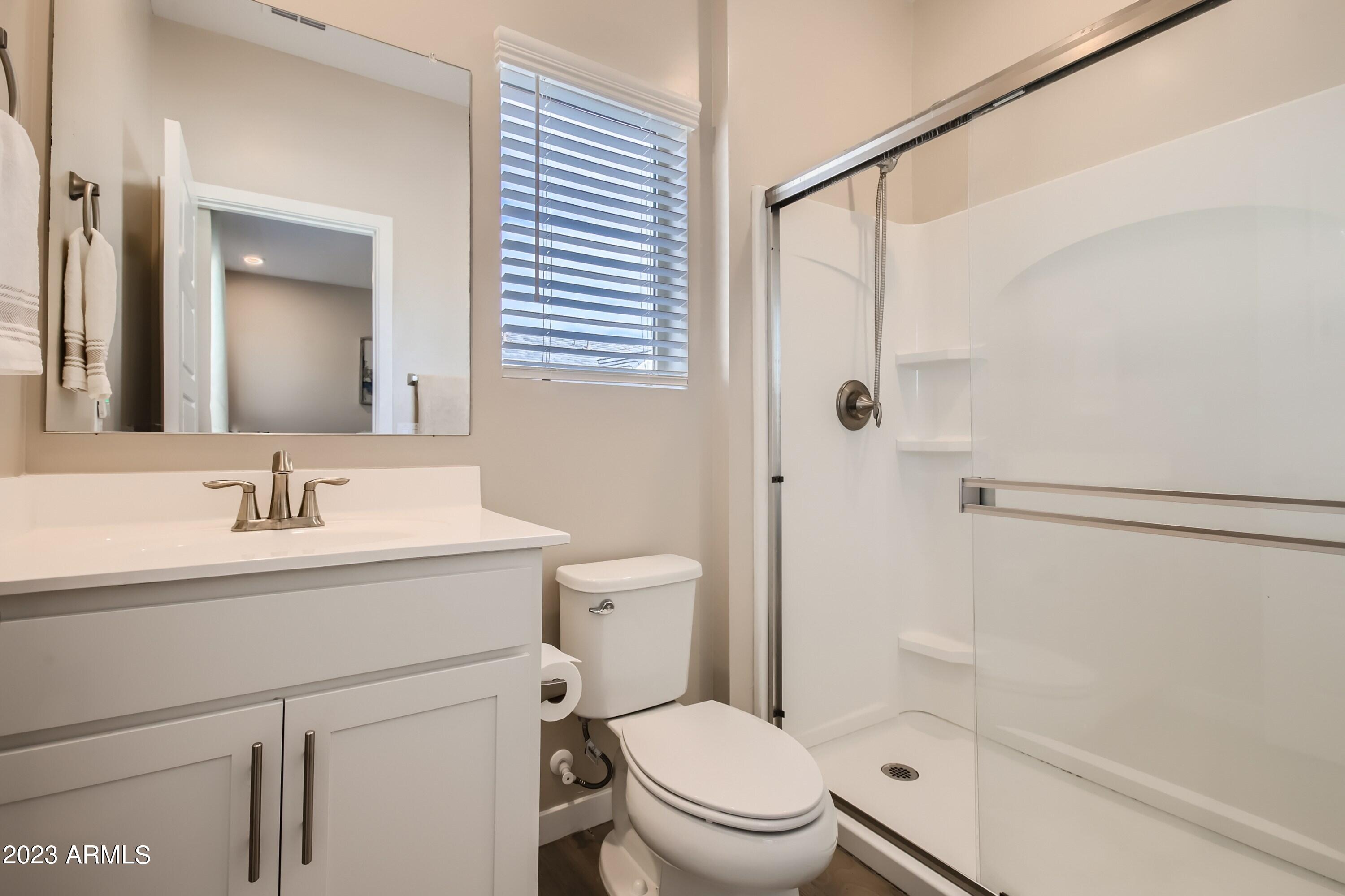 2241 West Griswold Road Phoenix, AZ 85021 - Photo 12 of 23 a bathroom with a granite countertop sink toilet a mirror and shower