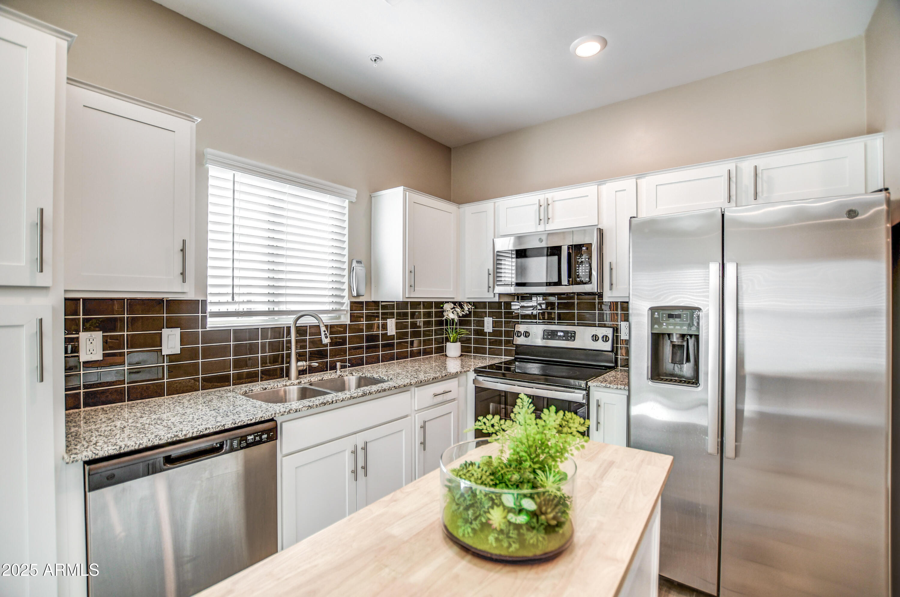 2241 West Griswold Road Phoenix, AZ 85021 - Photo 6 of 23 a kitchen with stainless steel appliances kitchen island granite countertop a refrigerator a sink a stove a dining table and chairs