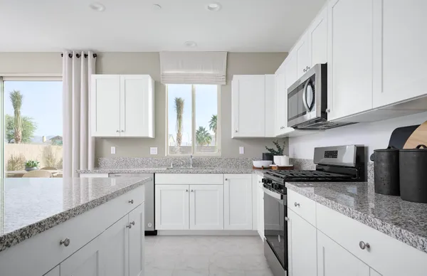 a kitchen with stainless steel appliances granite countertop a sink stove and cabinets