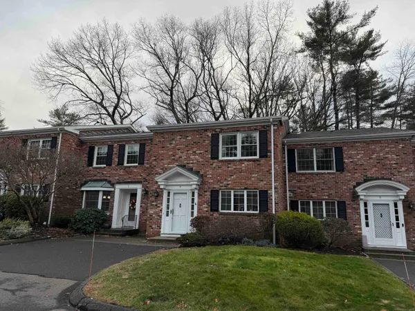front view of a brick house with a yard
