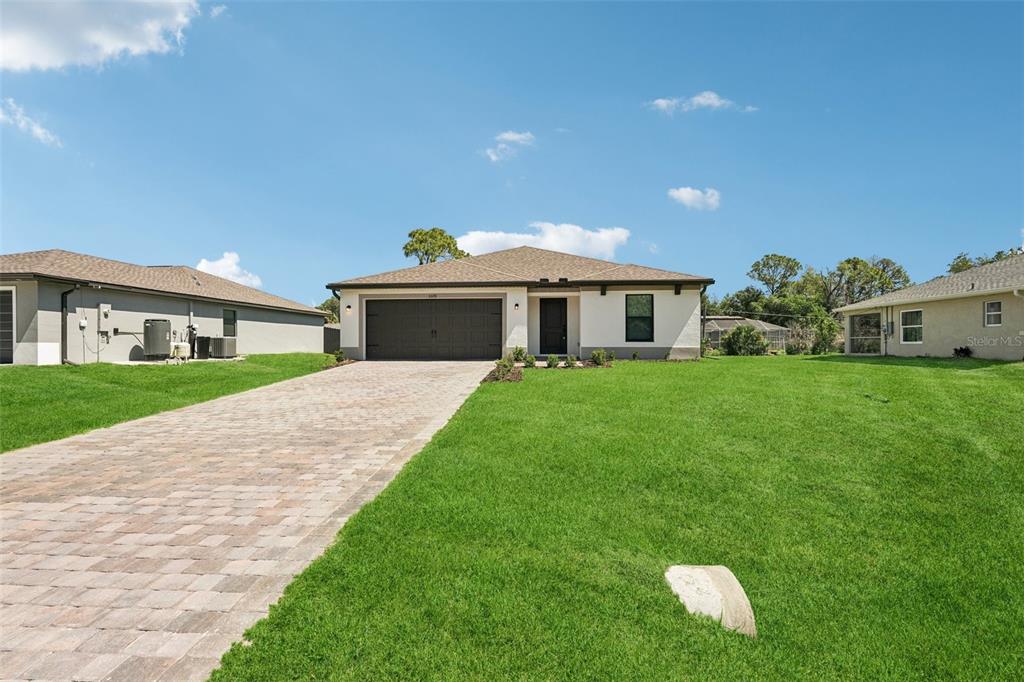 5237 Aberback Street North Port, FL 34291 - Photo 5 of 46 a front view of a house with a yard and garage