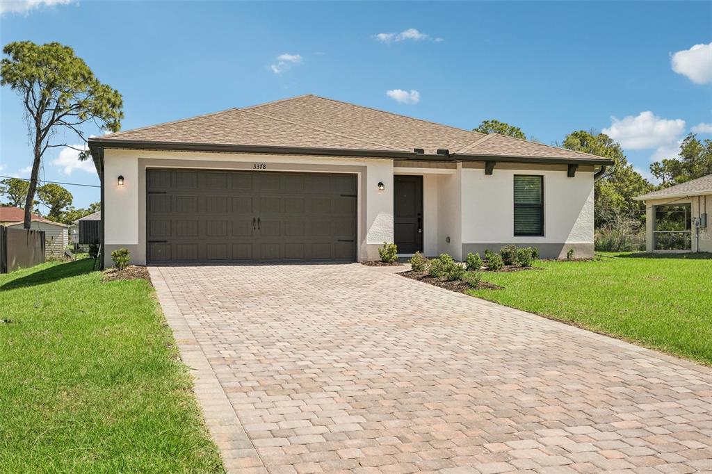 5237 Aberback Street North Port, FL 34291 - Photo 7 of 46 a front view of a house with a yard and garage