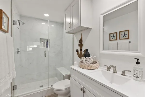 a bathroom with a granite countertop sink a toilet and shower
