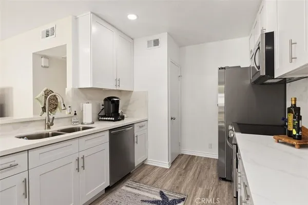 a kitchen with a sink appliances and cabinets