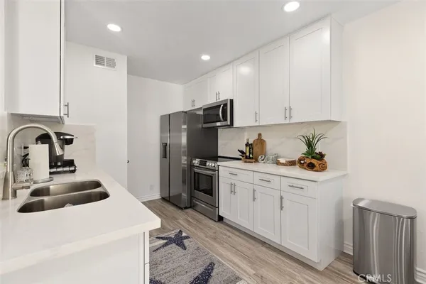 a kitchen that has a sink and a stove top oven