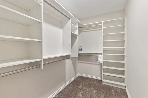 a view of walk in closet with empty racks