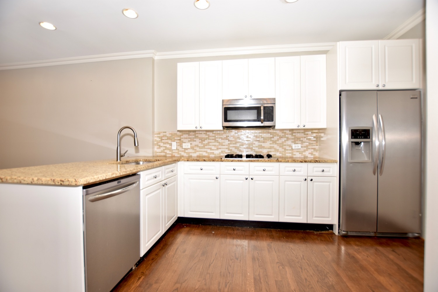 1801 West Diversey Parkway, Unit 18 Chicago, IL 60614 - Photo 9 of 32 a kitchen with granite countertop white cabinets and stainless steel appliances