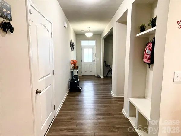 a view of a hallway with wooden floor and staircase