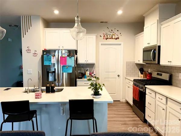 a kitchen with stainless steel appliances kitchen island granite countertop a sink and cabinets