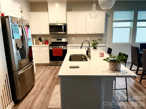 a kitchen with stainless steel appliances a stove refrigerator sink and microwave